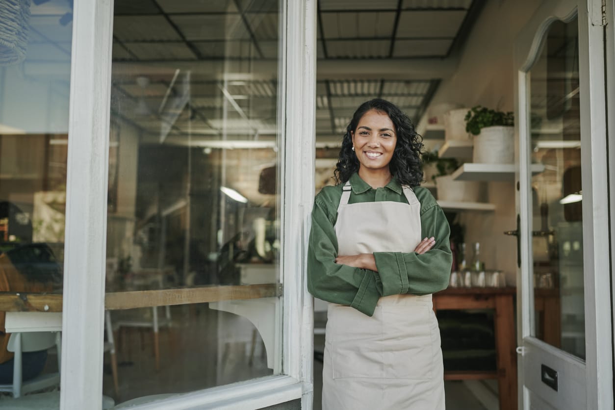 Smiling Small Business Owner Standing in Front of Their Shop